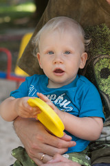 Baby in hands of adult with toy