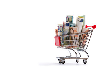 Shopping trolley full of euro money - banknotes - currency. Symbolic example of spending money in shops, or advantageous purchase in the shopping center.