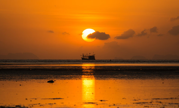 Fototapeta sunrise with clouds and siluate boat