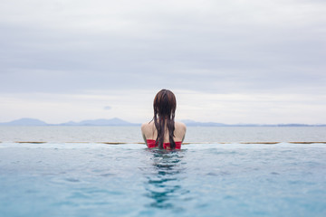 Young woman in bikini by the swimming pool