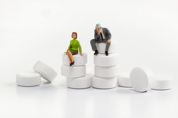 miniature people - people posing in front of pills
