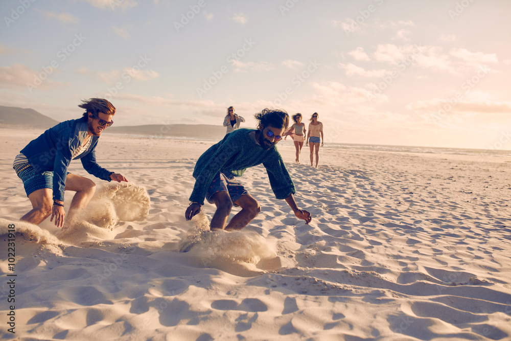 Wall mural young men running race on the beach