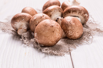 Fresh brown mushrooms on the wooden table.