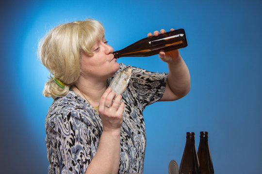 Female alcoholism. Lonely poor fat woman aged drinking beer and