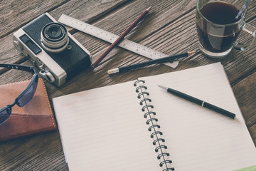 Vintage Film Look: cup of coffee with camera and notebook