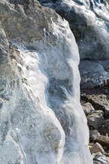 Fototapeta na wymiar Frozen rocks with ice in the winter lake