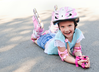 Cute smiling little girl in pink roller skates