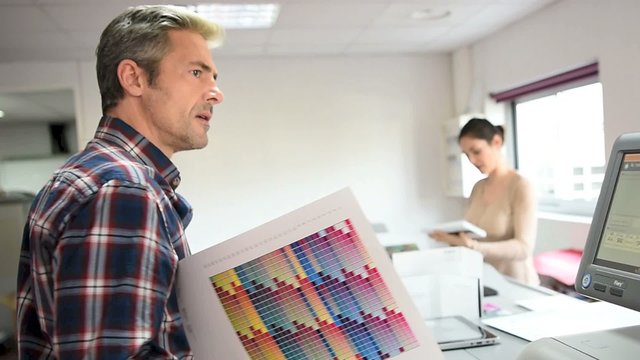 People in printing house checking color sample