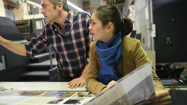 Man in printing house showing client proof documents