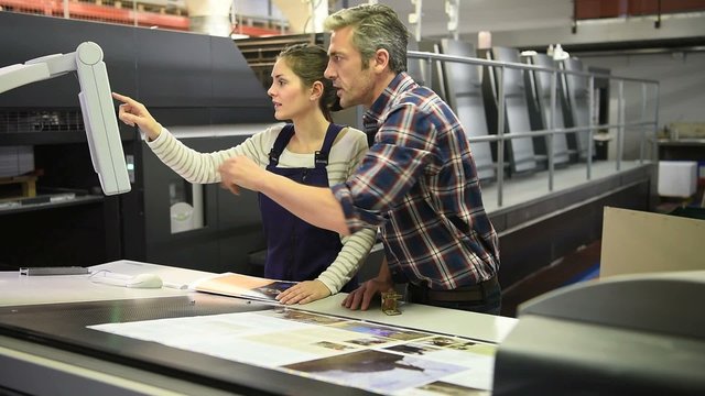 Man working with apprentice in printing house