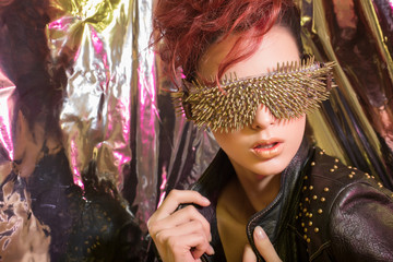 \young girl with red hair wearing glasses with gold spikes in th