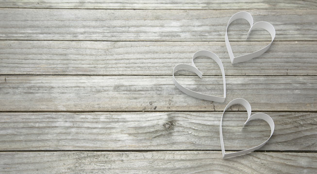 Three white hearts on a wood background