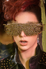 \young girl with red hair wearing glasses with gold spikes in th