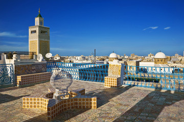 Tunisia. Tunis - old town (medina). Terrace of Palais d'Orient with ornamental wall covered tiles. There is minaret Zitouna Mosque on left side