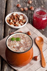 oatmeal with banana, jam and walnuts for breakfast, close-up