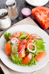Salad with greens, tomatoes, red onions and cucumber