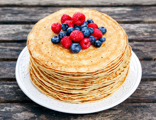 Fresh golden pancakes with raspberries, blueberries