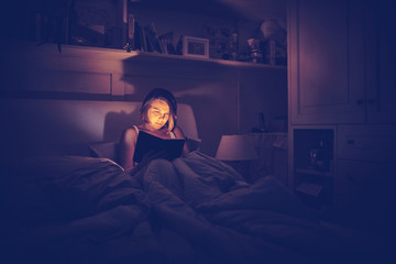 giovane ragazza legge libro a letto