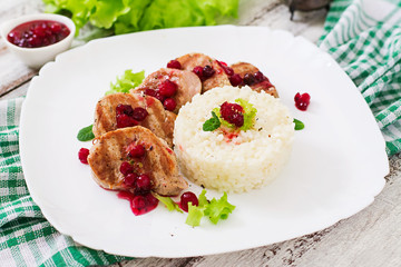 Pork medallions steak with cranberry sauce and a side dish of rice