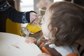 A little boy tries buckthorn tea.