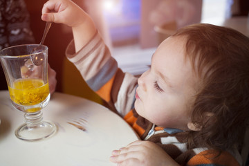 A little boy tries buckthorn tea.