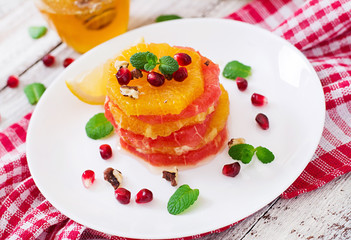 Fruit salad with grapefruit and orange, pomegranate seeds, honey and lemon, decorated with mint