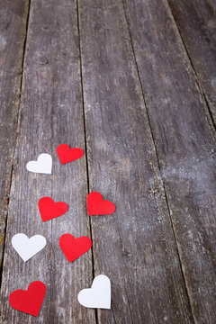 Valentines Day background with red and white hearts on old woode