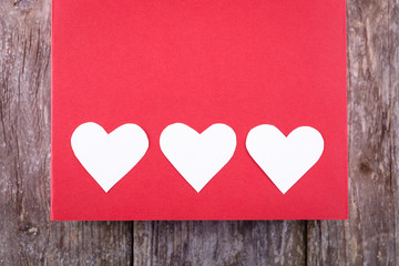 Valentines Day background - white hearts, on red and old wooden background. text space