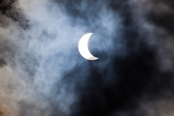 Obraz na płótnie Canvas Partial solar eclipse through clouds
