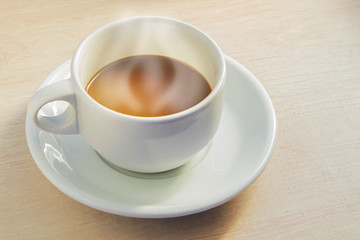 Cup of coffee on old white wooden table.
