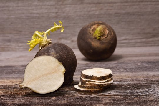 Black radish on wooden background