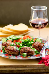 Lamb and veal cutlets with fresh vegetables salad, wine and bread