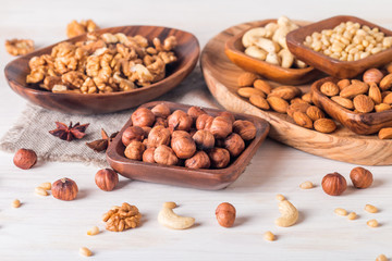 almonds, walnuts, hazelnuts cashews and pine nuts in wooden bowl