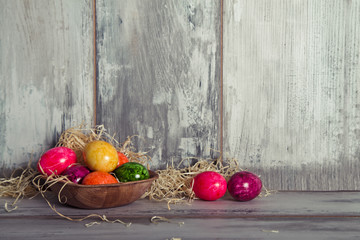 Uova colorati nel piatto di legno