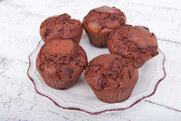 Baked chocolate muffins cakes on a plate on white