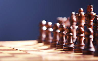 Chess pieces and game board on dark blue background