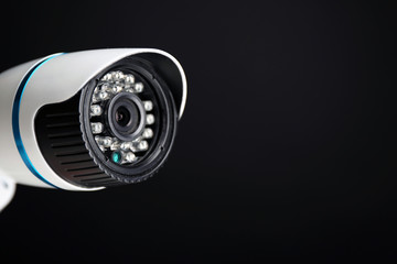 Security CCTV camera on blue background, closeup