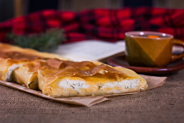 Tea, plaid, cake and a book. The atmosphere for a cozy romantic evening.