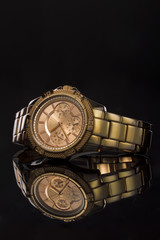 Gold watch on a plastic background
