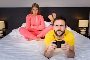 Young couple having playing videogames in bed