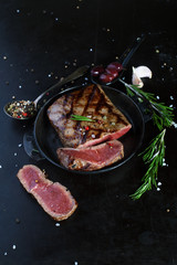 Grilled beef steak with aromatic spices and herbs in a pan