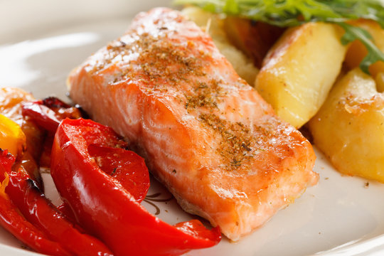 Grilled Salmon Fillet With Vegetables, Spices And Arugula On A Plate