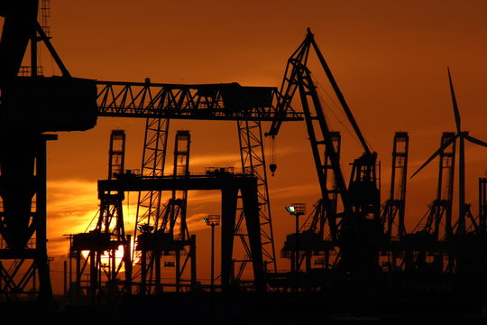 Harbor with cranes at sunset 
