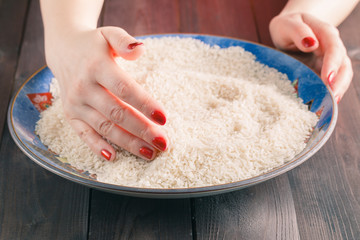 Close up of cook hands mixing white rice in a ceramic bowl