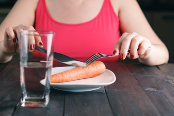 displeased woman keeping a strict diet and eating vegetables