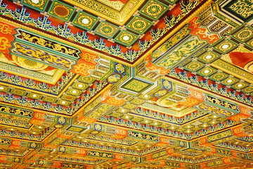 Gilded red patterns on the ceiling in interior 