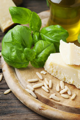 Basil, cheese, pine and olive oil on the wooden table