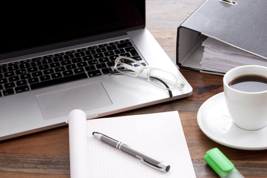 Büro Arbeitsplatz mit Notebook, Kaffee in Tasse, und leerem Papier auf Schreibtisch