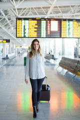Frau vor Anzeigetafel am Flughafen 