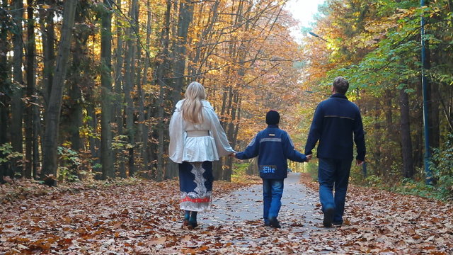 The happy family walks in autumn park, forest.  Child boy teen with Female, miss, lady. Childhood dreams and memories.